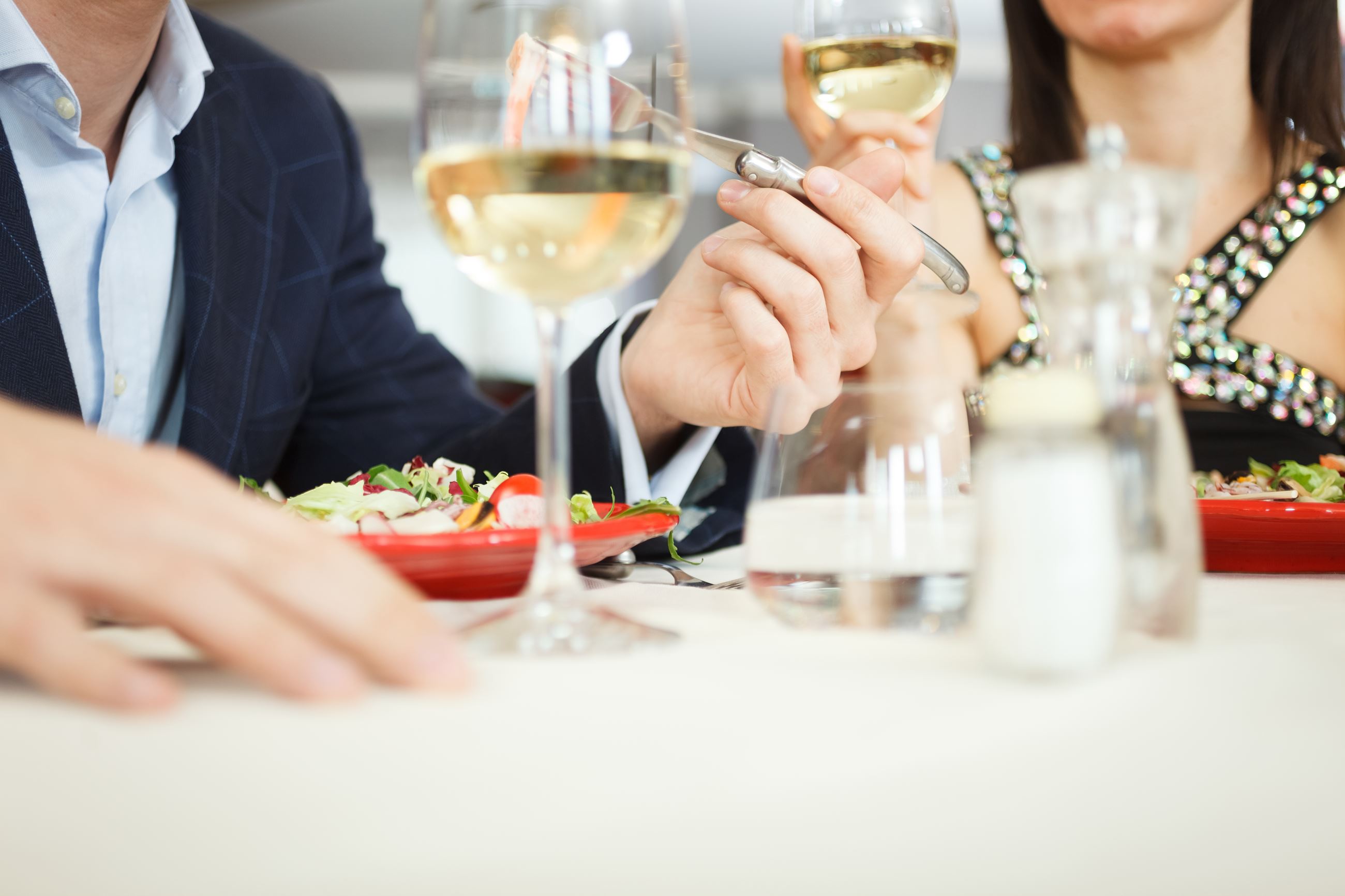 Man and woman at a table eating and sipping wine